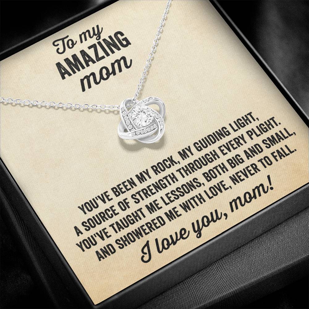 A necklace with a silver pendant featuring a love knot design, displayed in a box with a message for a mother.